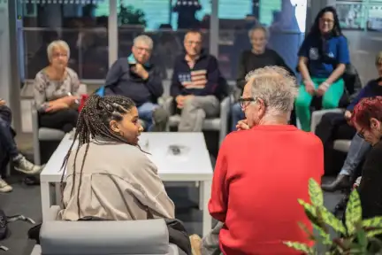 Une photographie d'un RDV 4C dans l'espace Vie du Citoyen des Champs Libres. Deux personnes d'âge différent se regardent.