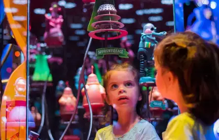 Une petite fille observant une figurine de l'Espace des sciences dans l'exposition Incroyable Cerveau