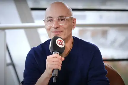 Une photographie de Bernard Werber tenant un micro de TVRennes dans la Bibliothèque des Champs Libres.