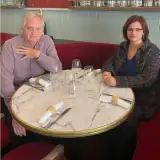 Une photographie de Thomas Coutrot et Coralie Perez attablés ensemble, regardant la caméra.